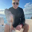 Angler sitting on board showing a sea bream caught with Fishing Trips Málaga