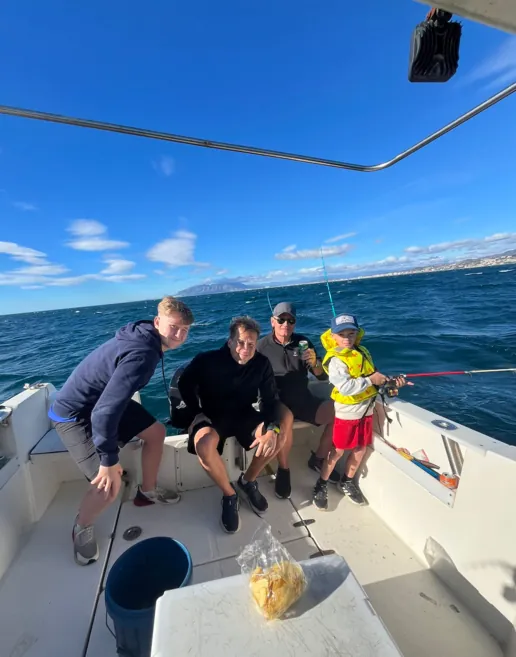 Group of friends and family on board the boat during a fishing trip in Málaga