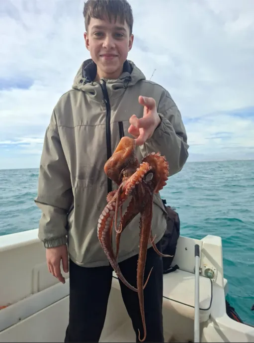 Boy showing an octopus caught during a fishing trip in Málaga