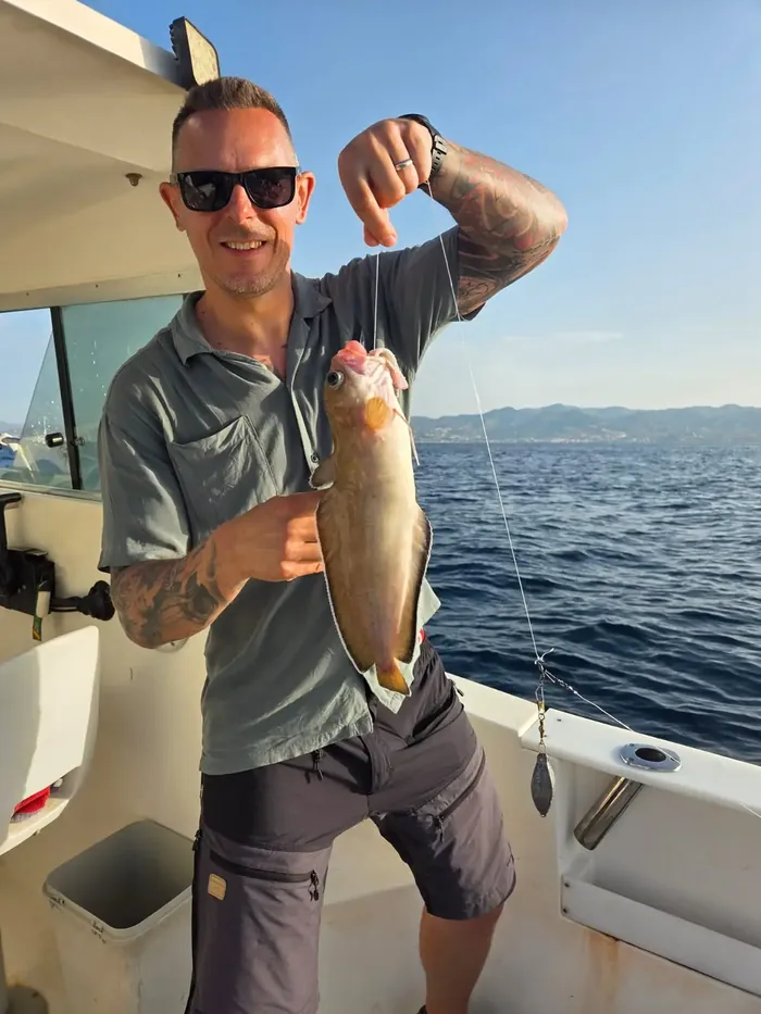 Angler showing his catch on board during a fishing trip in Málaga