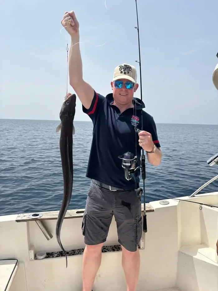 Angler lifting a conger eel caught on a fishing trip in Málaga