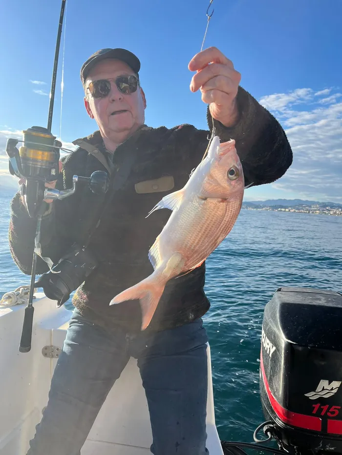Angler showing a freshly caught sea bream off the coast of Málaga