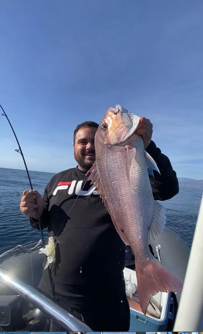 Smiling angler holding a large sea bream caught off the coast of Málaga