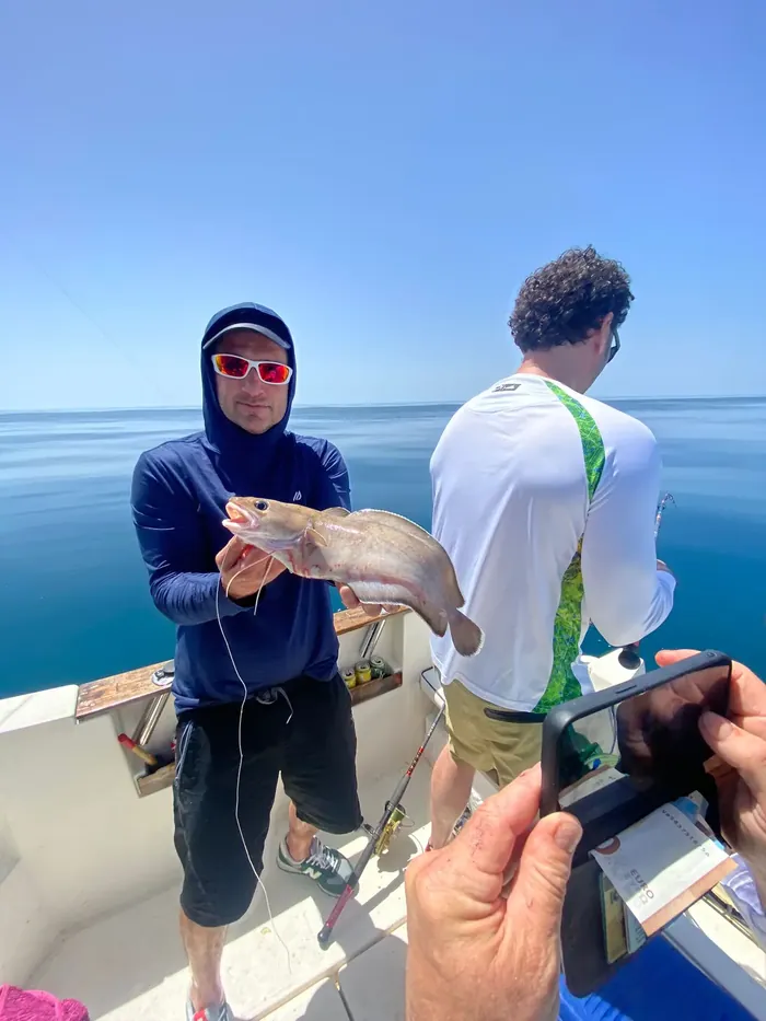 Anglers on board showing a catch during a fishing trip in Málaga