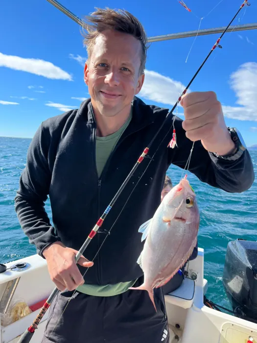 Smiling angler showing his catch on the rod with Fishing Trips Málaga
